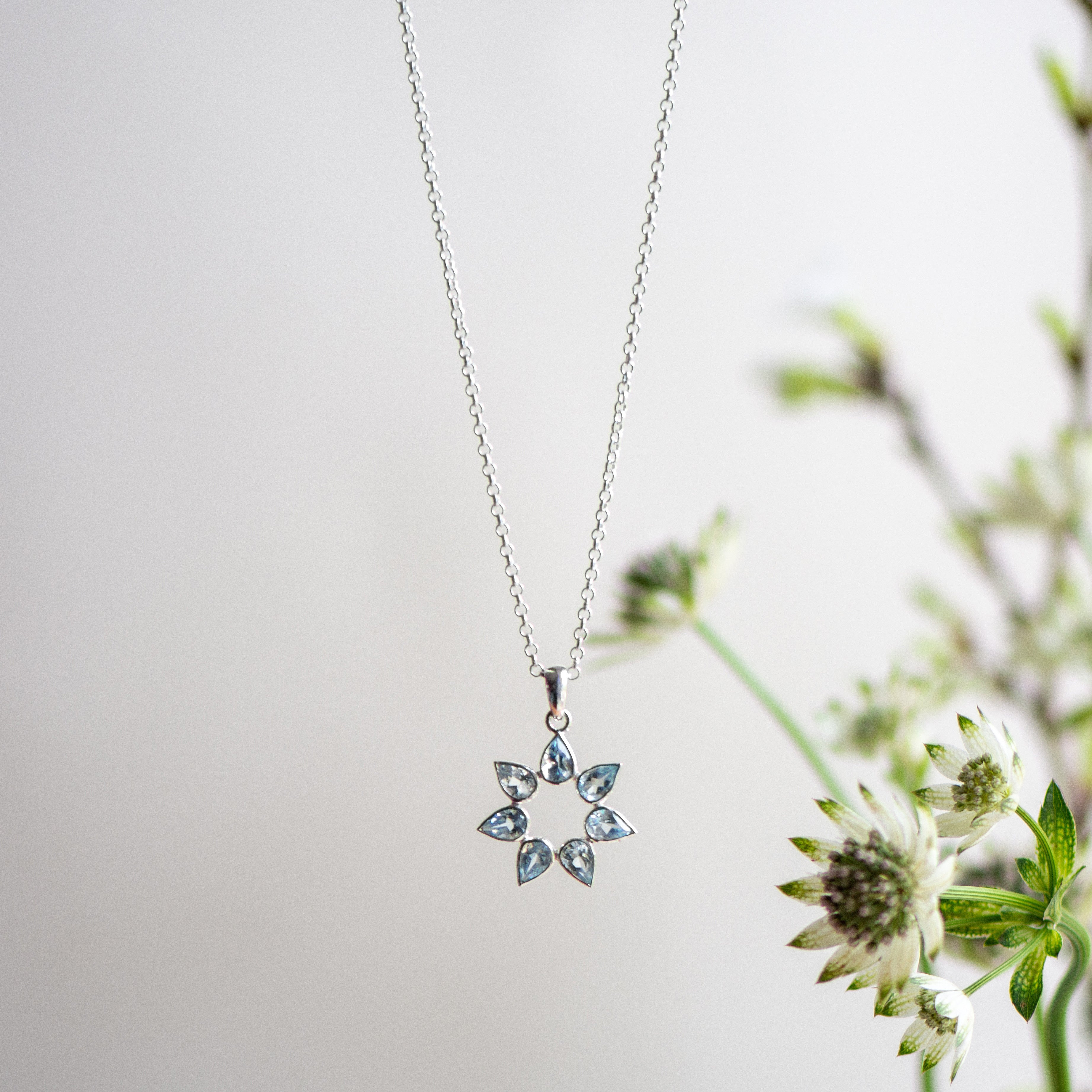 flower silver pendant with sky blue topaz from memara